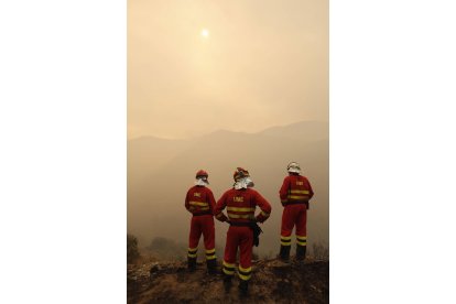 Tres militares de la UME observan la nube de humo que invade La Cabrera.