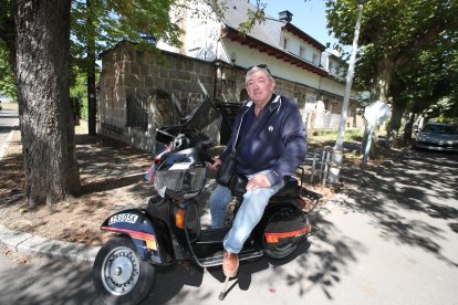 José Joaquín, con su Vespa de 33 años, en la puerta de su antigua casa en Compostilla. ANA F. BARREDO
