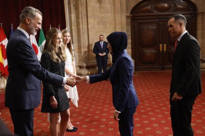 El rey Felipe junto a la princesa Leonor saludan a la ciclista afgana Masomah Ali Zada, integrante del Equipo Olímpico de Refugiados, premio Princesa de Asturias de los Deportes, este viernes. EFE / BALLESTEROS