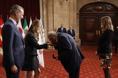 La princesa Leonor entrega al periodista y escritor polaco Adam Michnik, Premio Princesa de Asturias de Comunicación y Humanidades, una insignia ante el rey Felipe, este viernes. EFE / BALLESTEROS