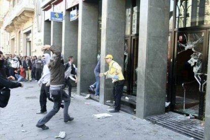 Un manifestante reprocha su acción a un violento tras la rotura de cristales de una sucursal bancaria. Foto: JULIO CARBÓ