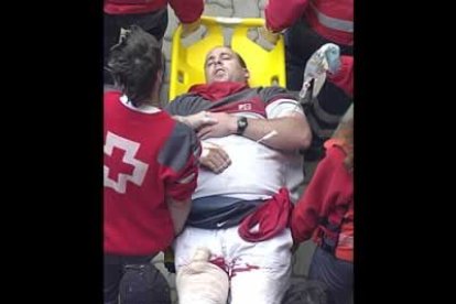 El corredor Raúl Jiménez es atendido por la Cruz Roja tras recibir una cornada en la pierna derecha en el callejón de la plaza de toros de Pamplona.