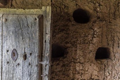 Nidales hechos en forma de cuarto de espera sobre una pared de tapial. Típica puerta de madera.
