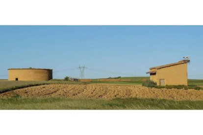 Palomares en Santas Martas, uno circular y otro cuadrado con el nido de la cigüeña aposentado sobre su tejado.