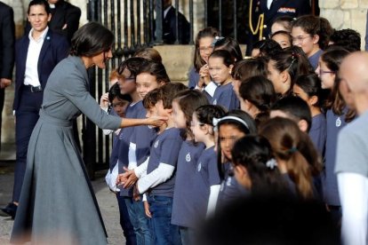 La reina Letizia saluda a los niños y niñas que componen la banda de gaitas y el Coro de la Fundación Princesa de Asturias (FPA), este jueves a la salida del acto oficial de bienvenida a la familia real con motivo de la entrega, mañana viernes, de los premios del mismo nombre. EFE/Ballesteros
