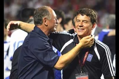 Scolari recibe el consuelo de un feliz Rehhagel, que se ha convertido en el mayor vencedor de la Eurocopa.