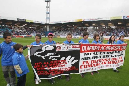 Los hijos de los encerrados en el Pozo Santa Cruz saltaron al césped con una pancarta que volvía a exigir la defensa del carbón. Foto: De la Mata.