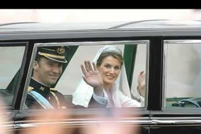 La corona de rosas blancas está cruzada por una banda azul, por la que asoma otra con los colores de la bandera de España, en la que se lee «Felipe y Letizia, siempre en nuestra memoria».