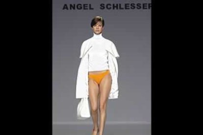 Abrigo de verano en blanco con jersey de cuello vuelto a tono y pantalón extracorto naranja con sandalias a juego.