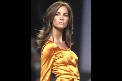 Eugenia Silva, con una ajustada chaqueta en raso oro,recogida a la cintura con un pequeño cinturón forrado del mismo tejido.
