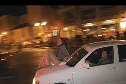 Esta joven viaja subida al capó de un coche. Cualquier cosa sirve para celebrar el primer título logrado por un español en Fórmula 1.