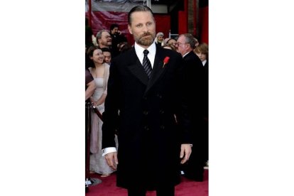 Viggo Mortensen lució levita negra, barba espesa y flor roja en la solapa.