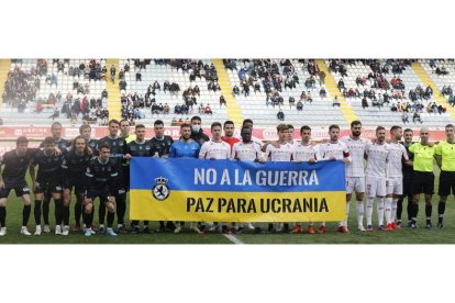 Los dos equipos y el trío arbitral posan antes del partido contra la guerra. MARCIANO PÉREZ