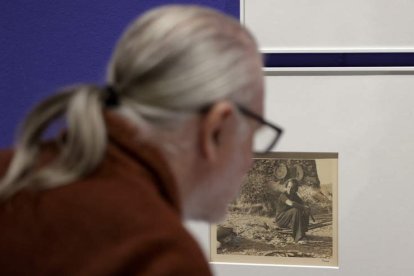 Un visitante contempla una foto de Rahola. A la derecha, imagen de gente en la cola del pan (1936-37). QUIQUE GARCÍA / HEREDEROS DE MEY RAHOLA