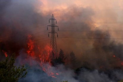 Vista del incendio forestal en el área de Varybobi, un suburbio al noreste de Atenas (Grecia). Tres suburbios de Atenas fueron evacuados ayer por un fuerte incendio que ha arrasado casas, vehículos y locales comerciales, y ha causado incidencias en la red de trasportes y el suministro eléctrico de la capital griega, que vive la peor ola de calor en décadas. EFE/ Orestis Panagiotou