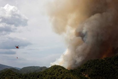 Un helicóptero de la UME trabaja en la extinción del incendio en la sierra de Santa María de Miralles. El incendio, que se originó ayer en Santa Coloma de Queralt (Tarragona),saltó a la provincia de Barcelona con un frente de 10 kilómetros y una cabeza muy activa de dos kilómetros, a cuyo paso ha arrasó más de 1.190 hectáreas. EFE/Susanna Sáez