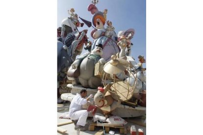 Un artista retoca su obra en las fallas de Valencia. Foto: HEINO KALIS | REUTERS