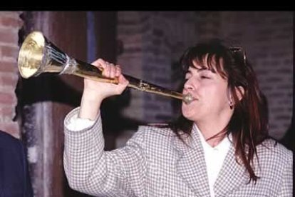 Una joven toca la tradicional trompa con la que se rompe el silencio del Viernes Santo.