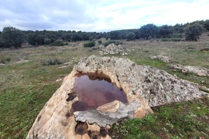 La roca rellena de cemento y convertida en un abrevadero, donde no se ven ya las cazoletas. JUAN CARLOS CAMPOS