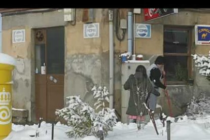 Una mujer limpia la entrada a su establecimiento, en el barrio de Cantamilanos ubicado en las afueras de León