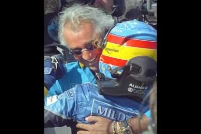 El flamante ganador del Gran Premio de Hungría es felicitado por el patrón del equipo Renault Flavio Briatore.