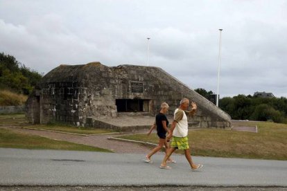 Turistas ante un bunker en la playa de Omaha, en el 2013.