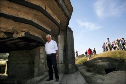 Un turista italiano;ante un bunker destruido en Pointe du Hoc.