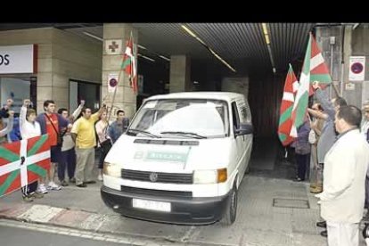 Momento en el que un furgín traslada los restos del ex dirigente de HB en presencia de un grupo de simpatizantes.