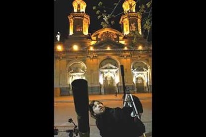 Un aficionado a la astrología observa el curioso fenómeno frente a la catedral de Santiago de Chile.
