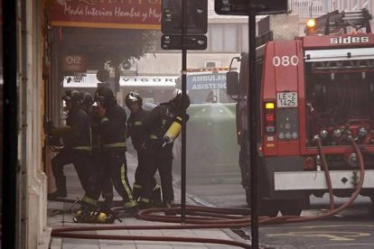 Los bomberos acceden al siniestro por un portal aledaño al Ayuntamiento de León. Peio García | Ical.