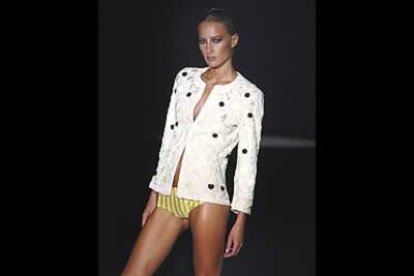 Chaqueta con joyas bordadas, se acompaña de un micropantalón con rayas verticales.
