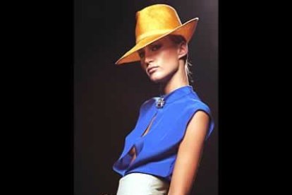 Blusa de seda azul con abertura, sin botones, con un broche en el cuello y pantalón recogidao a la cintura con amplio cinturón.