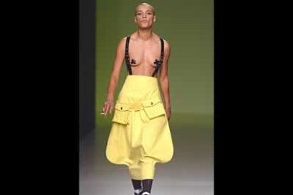 Modelo unisex de falda con bolsillos y tirantes a tono con botas.