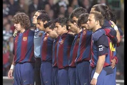 Los jugadores del Barça viven abrazados el minuto de silencio que guardaron antes de su partido en Glasgow.