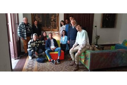 Las personas sin hogar que han participado en la exposición posan ante una de las obras de arte realizadas por ellos para la muestra de León. DL
