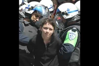 Una manifestante antiglobalización es arrestada por la policía en Montreal cuando protestaba ante la reunión de la Organización Mundial del Comercio.