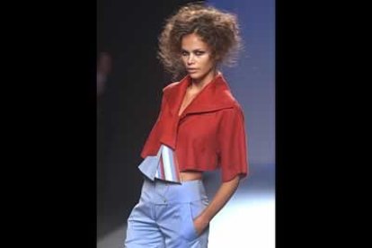 Original chaqueta, con mangas y cuellos amplios, enlazado con una tela. El Pantalón bermuda en algodón en tono celeste.