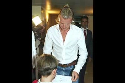 El nuevo fichaje merengue firma un autografo a un niño, a su llegada a la clínica donde se sometió a un reconocimiento médico.