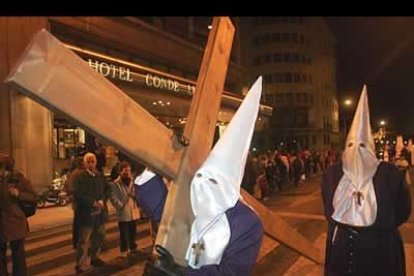 Los cofrades aparecieron ataviados con su tradicional túnica morada y capillo alto blanco. Tras ellos penitentes anónimos, algunos de ellos descalzos, procesionaban con sobriedad y resignación.