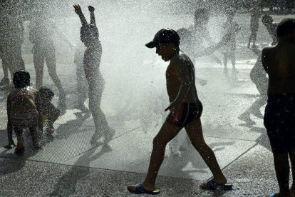 Niños se refrescan en una fuente en Pamplona. / ÁLVARO BARRIENTOS (AP)
