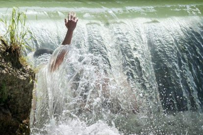 Unos niños se bañan en un riachuelo en el Jardín Inglés de Múnic, Alemania. / PETER KNEFFEL (AP)