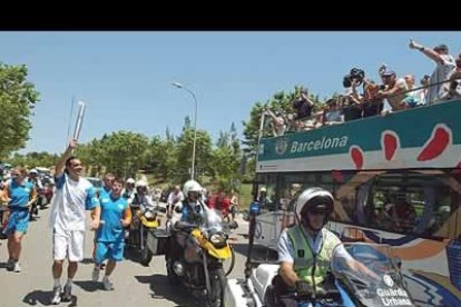 Tras su breve periplo por Madrid, la llama olímpica se trasladó a Barcelona. En la imagen, el tensita Sergi Bruguera corre con ella, provocando el regocijo de los turistas