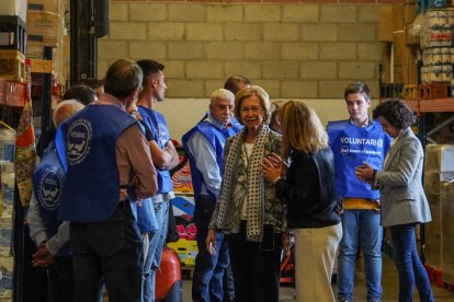 Juani Pérez explica a la reina la labor del voluntariado en el almacén. MIGUEL F. B.