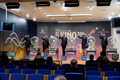Operarios muestran el número del primer premio del sorteo extraordinario de lotería del Niño, el 41.665, vendido íntegramente en Logroño, este jueves en el salón de sorteos de Loterías y Apuestas del Estado EFE