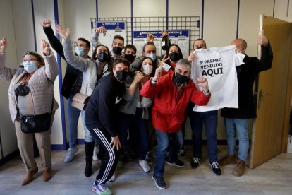 Agraciados con el número 19467 celebran el tercer premio del sorteo de la Lotería del Niño en una administración en Valencia, este jueves. El premio está dotado con 250.000 euros por serie (25.000 euros al décimo). EFE/ JUAN CARLOS CÁRDENAS
