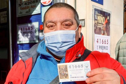 Juan Jiménez, uno de los agraciados, muestra este jueves el décimo ganador del primer premio del sorteo extraordinario de la lotería del Niño a la puertas de la Administración de Lotería número 6 de Logroño. EFE / RAQUEL MANZANARES