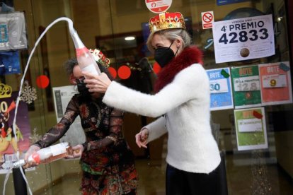 Pilar García y su socia celebran la venta del número 44469, segundo premio del sorteo extraordinario de la lotería del Niño, este jueves en el estanco situado en la calle Padre Buenaventura de Paredes, número 2, en Oviedo. El segundo premio está dotado con 750.000 euros por serie (75.000 euros al décimo) y ha sido vendido en Oviedo y Gijón.  EFE / RAQUEL MANZANARES