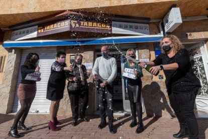 El gerente de la administración de lotería de la pedanía murciana de Sangonera la Seca, Antonio Garnés (c), junto a su madre María Jesús (3i) y sus hermanas Cande (2d), Noelia (2i) y Silvia (d) celebran con cava la venta de números del 44.469, agraciaado con el segundo premio del sorteo extraordinario de la lotería del Niño, este jueves. EFE/MARCIAL GUILLÉN