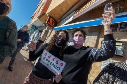 Noelia Garnés (d), trabajadora de la administración de lotería de la pedanía murciana de Sangonera la Seca, celebra con una clienta tras vender números del 44.469. MARCIAL GUILLÉN