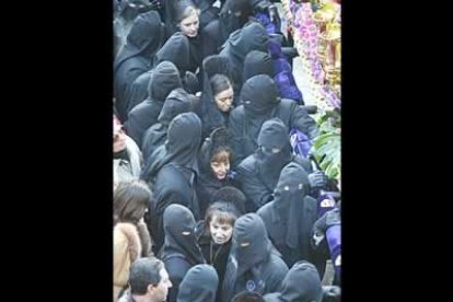 Una fila de manolas cruza entre los braceros antes de que se produzca el encuentro. Nadie quiere perderse uno de los momentos más emocionantes de la Semana Santa en León.